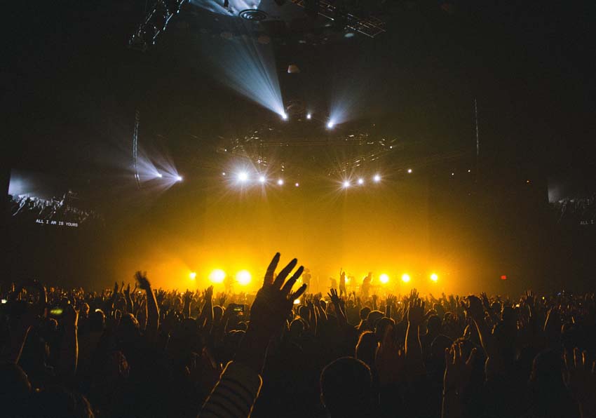 An illuminated stage and audience attending a concert
